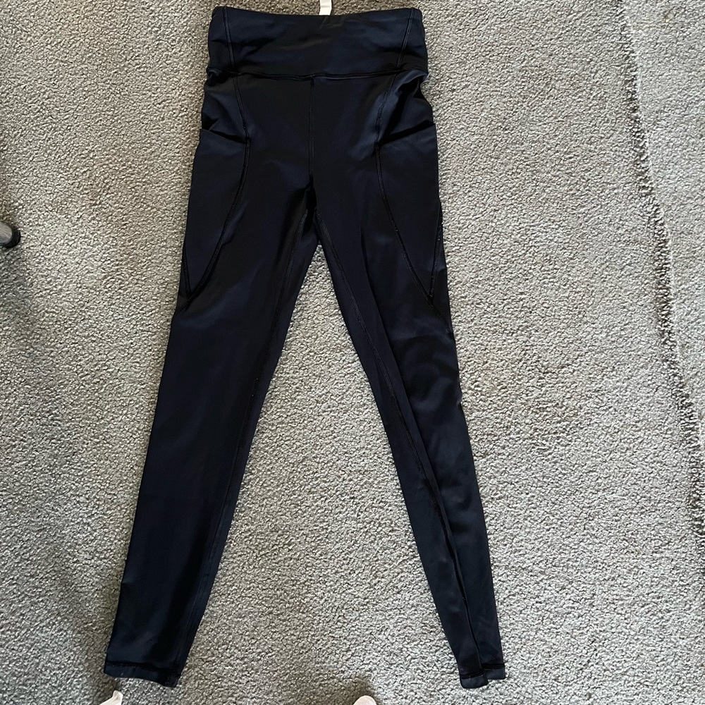 Black Lululemon leggings with side pockets and back zipper.